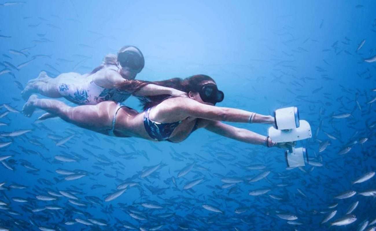 Dos chicas en el mar con gafas snorkel propulsadas por un sea scooter más vendido de amazon de la marca WhiteShark
